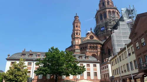 Red-brick cathedral under renovation, surrounded by buildings.
