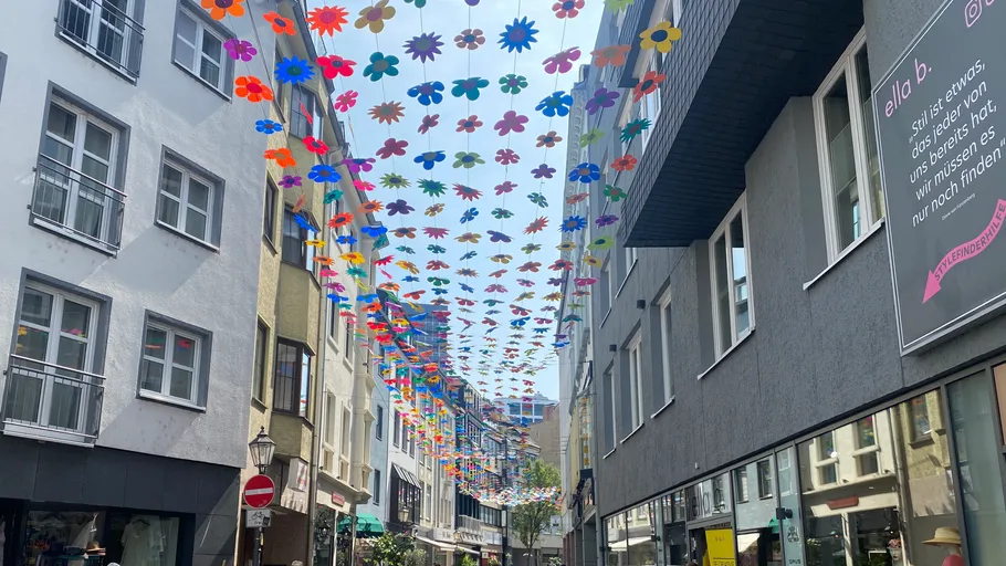 Bunte Blumendekorationen über Stadtstraße aufgehängt.