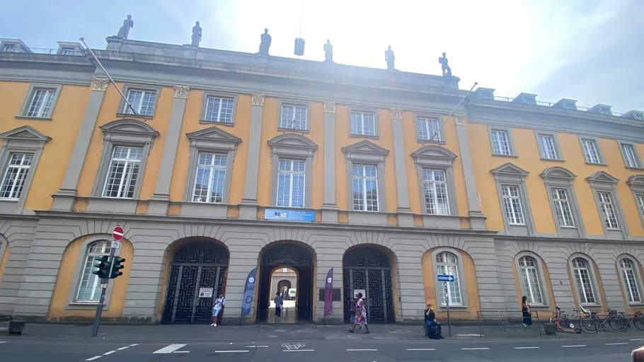 Historic building with large arched entrance, sunny day.
