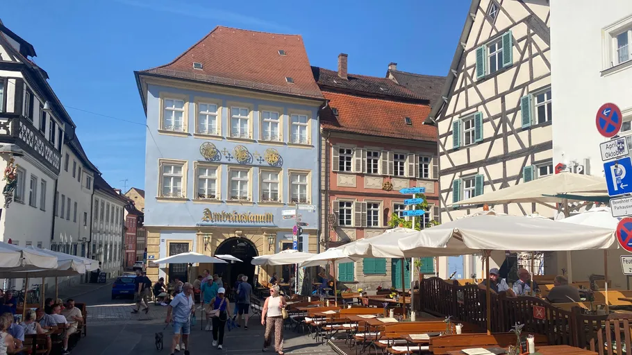 Menschen spazieren auf einem historischen deutschen Platz.