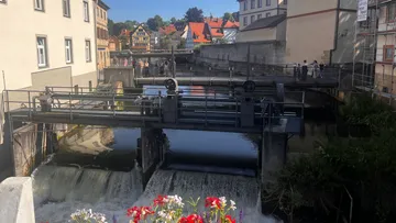 Small river dam in quaint village setting.