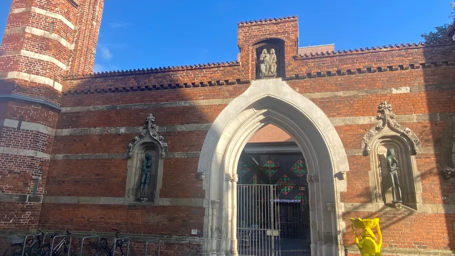 Gothic archway with brick wall, shadowed person.