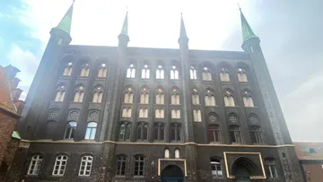 Historical brick building with four towers.