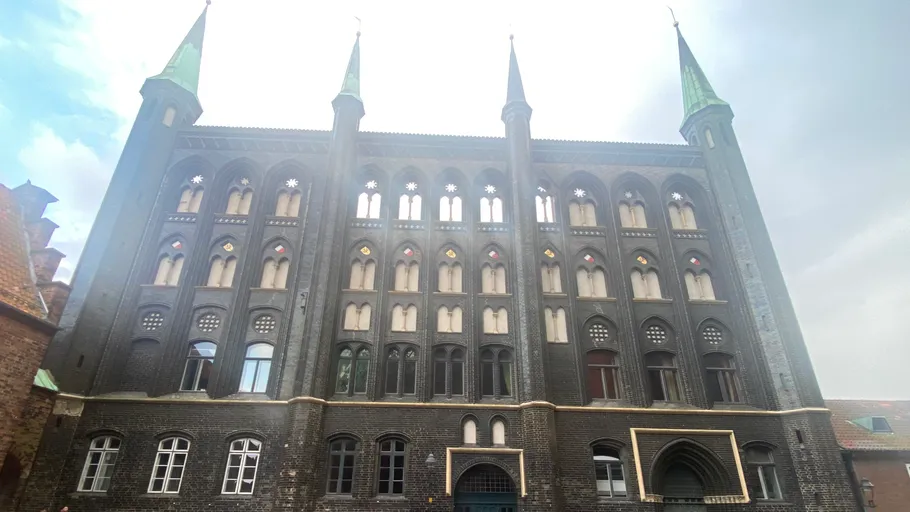 Historisches Ziegelgebäude mit vier Türmen.