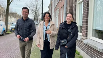 Three people walking on a street.