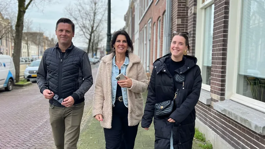 Three people walking on a street.