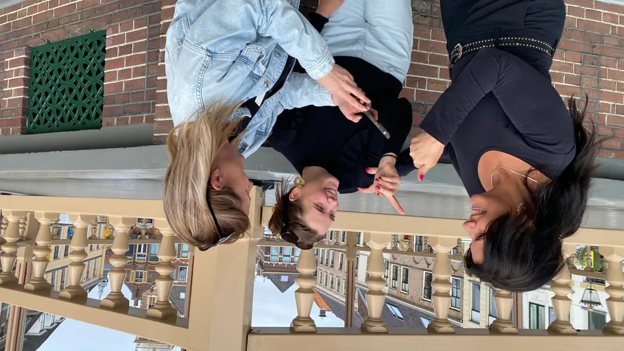 Drei Frauen plaudern auf einem Balkon.