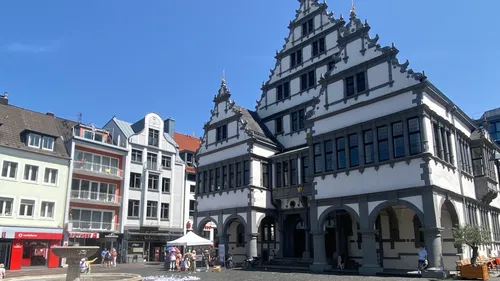 Historisches Gebäude mit Zierfassade, sonniger Tag.