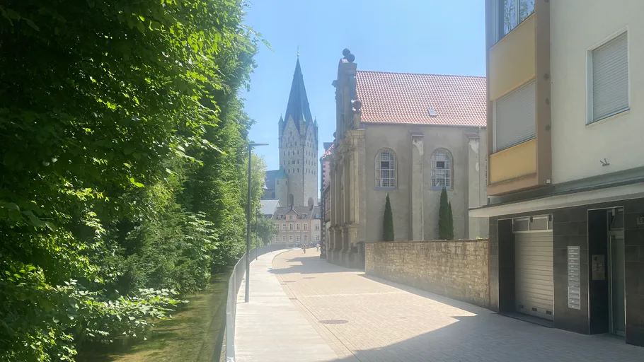 Kirchturm über einer sonnigen Straße.