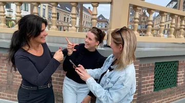 Three women talking and laughing together outside.