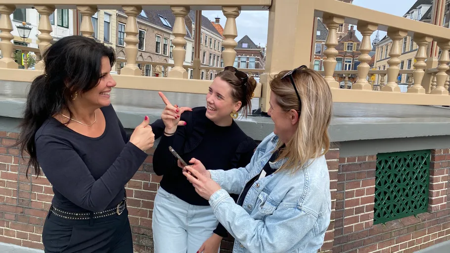 Drei Frauen unterhalten sich lachend im Freien.