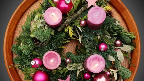Christmas wreath with candles on wood background.