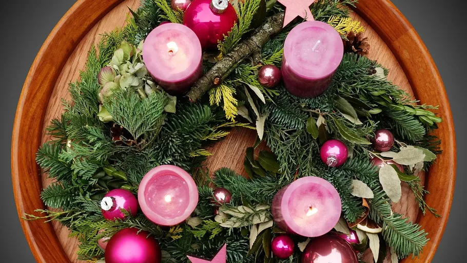 Christmas wreath with candles on wood background.