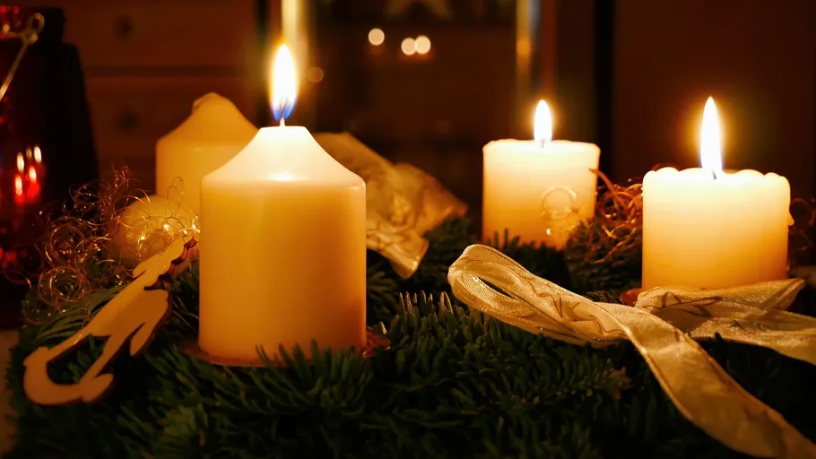 Candles burning on a Christmas wreath.
