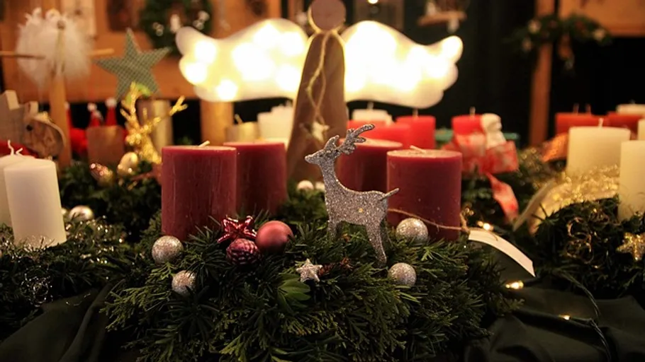 Christmas wreath with candles and reindeer decoration.