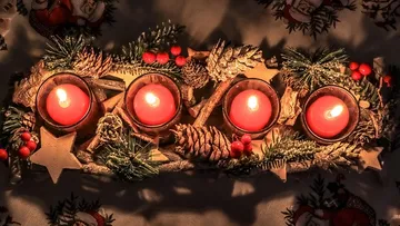 Four red candles on decorated centerpiece.