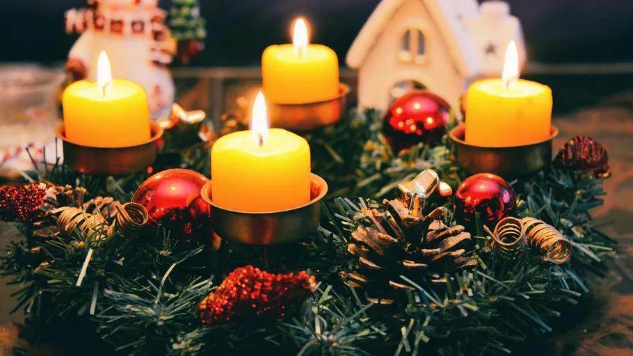 Adventskranz mit vier brennenden Kerzen.
