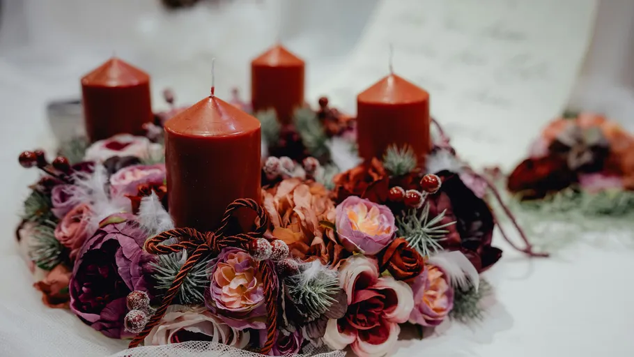 Wreath with red candles and flowers, indoors.