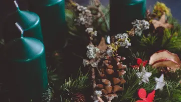 Grüne Kerzen auf Adventskranz dekoriert.
