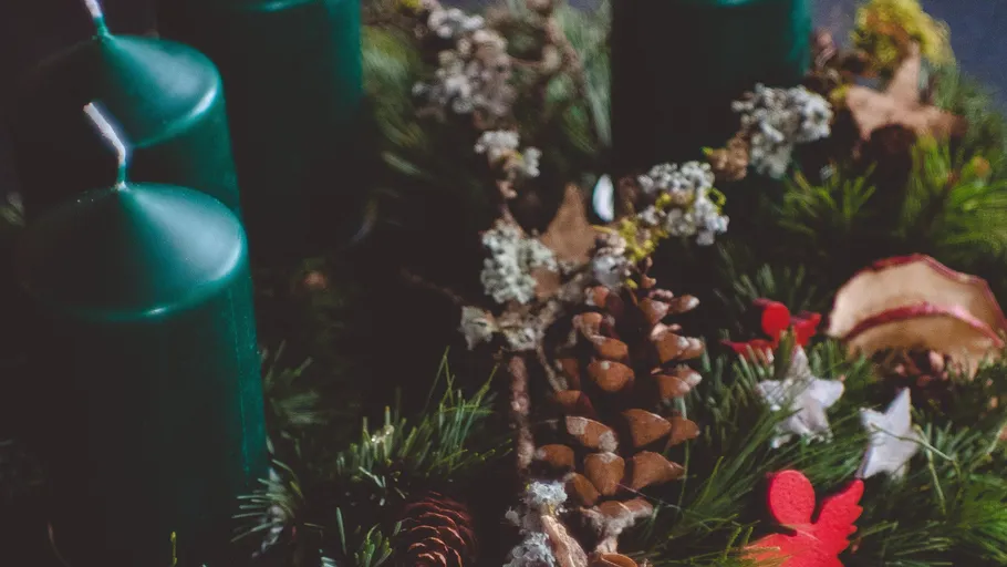 Green candles on a decorative Christmas wreath.