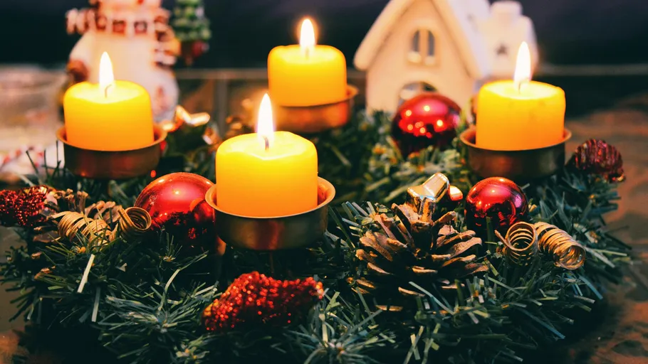 Adventskranz mit vier brennenden Kerzen, festliche Dekoration.