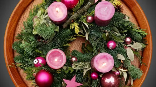 Weihnachtskranz mit Kerzen und Kugeln.