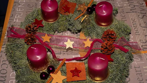 Adventskranz mit roten Kerzen und Dekorationen.