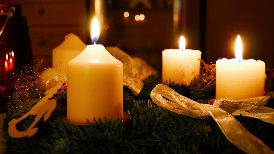 Four lit candles on an Advent wreath.