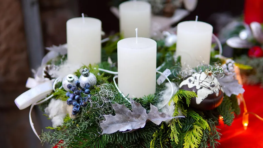 Vier Kerzen auf einem geschmückten Adventskranz.