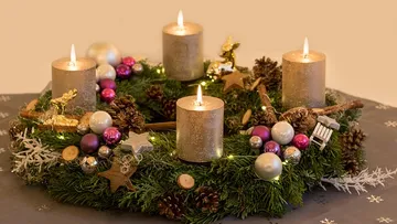 Wreath with four lit candles and ornaments.
