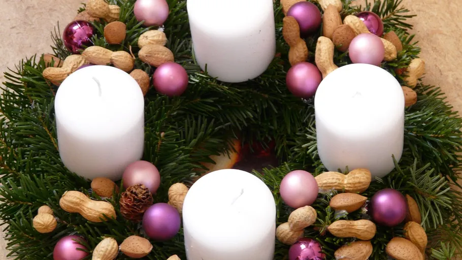 Weihnachtskranz mit Kerzen und Ornamenten.