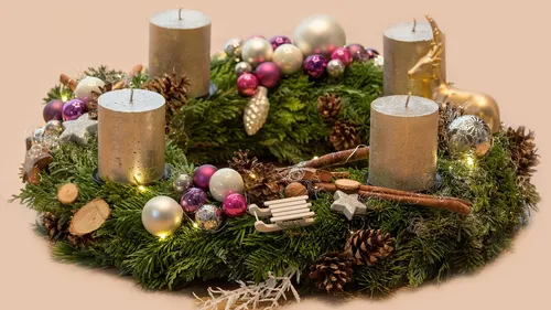 Candle-decorated Christmas wreath with ornaments.